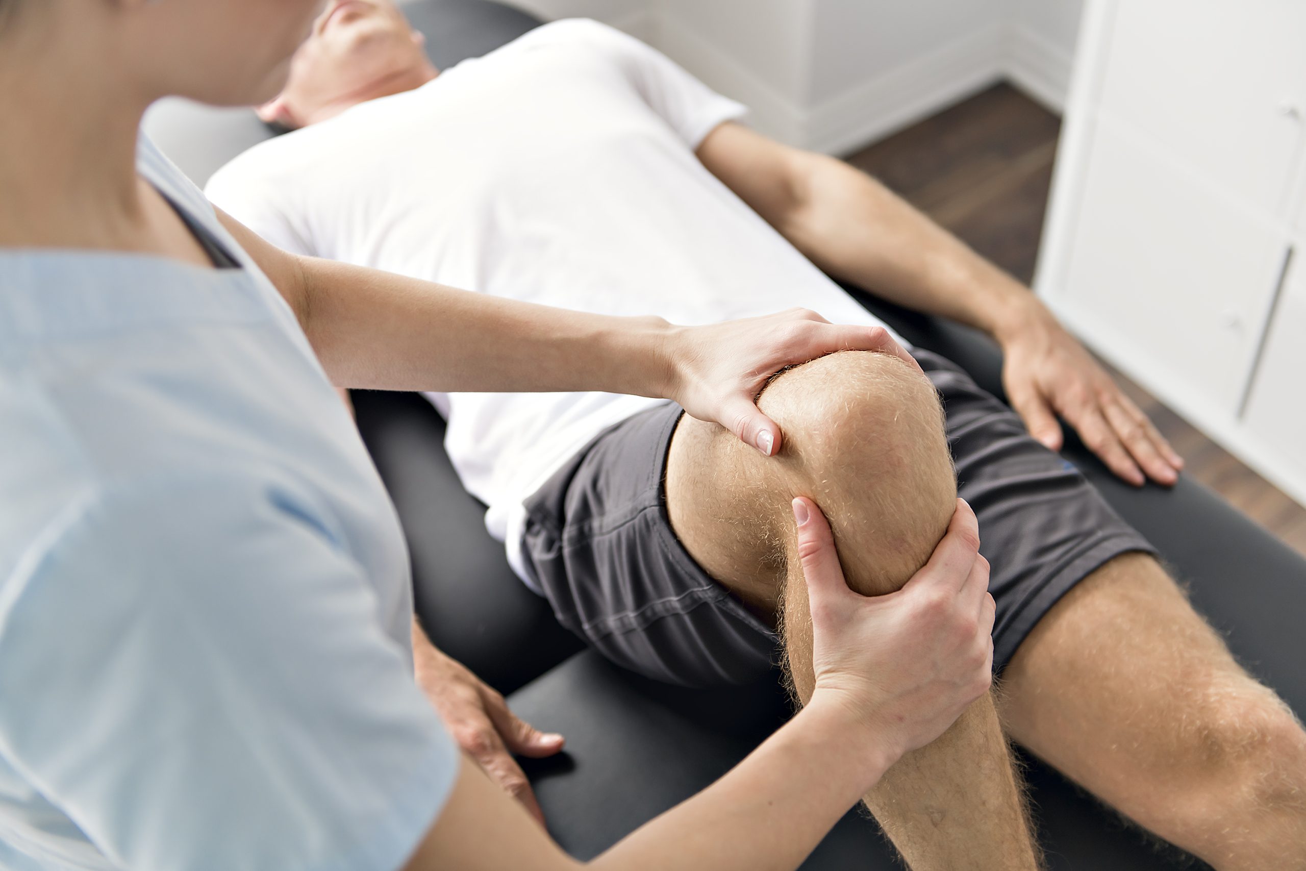 A Patient at the physiotherapy doing physical exercises with his therapist